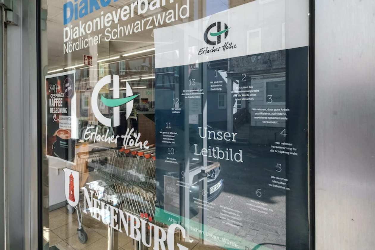 Schaufenster des Diakonieverbands N&ouml;rdlicher Schwarzwald mit dem Logo der Erlacher H&ouml;he und einem Leitbildplakat
