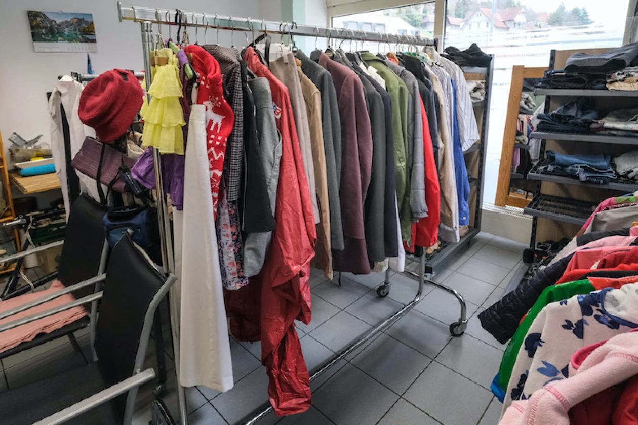 In einem Raum sind Kleiderst&auml;nder mit verschiedenen Jacken und M&auml;nteln in unterschiedlichen Farben zu sehen.